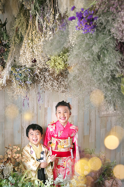 ドライフラワーの中の３歳女の子と赤ちゃん記念写真